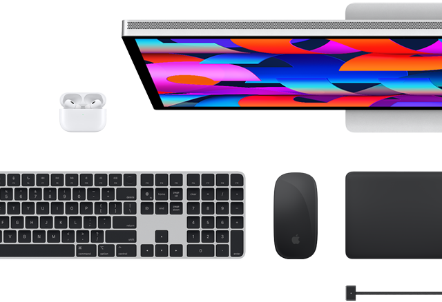 Draufsicht auf ausgewähltes Mac Zubehör: Studio Display, Magic Keyboard, Magic Mouse, Magic Trackpad, AirPods und MagSafe Ladekabel
